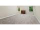 A bedroom featuring neutral walls, gray carpet, and windows providing view of green outdoor foliage at 1009 Blue Larkspur Ave, Wake Forest, NC 27587