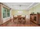 A dining room with natural light from the windows and a wooden table in the center with hard wood flooring at 1009 Blue Larkspur Ave, Wake Forest, NC 27587