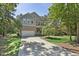 Beautiful home featuring a spacious driveway, attached garage, and lush green lawn surrounded by mature trees at 1009 Blue Larkspur Ave, Wake Forest, NC 27587