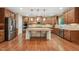 A kitchen featuring wood cabinets, stainless steel appliances, granite counters and a central island with seating at 1009 Blue Larkspur Ave, Wake Forest, NC 27587