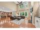 Open-concept living room with hardwood floors, a fireplace, high ceilings, and an adjacent kitchen at 1009 Blue Larkspur Ave, Wake Forest, NC 27587