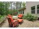 Secluded brick patio with comfortable seating surrounded by lush landscaping and mature trees at 1009 Blue Larkspur Ave, Wake Forest, NC 27587
