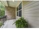 Cozy porch with brick and neutral siding, potted plants, and great light for relaxing at 1009 Blue Larkspur Ave, Wake Forest, NC 27587