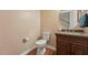 Elegant powder room featuring a granite countertop, round mirror, and hardwood flooring at 1009 Blue Larkspur Ave, Wake Forest, NC 27587