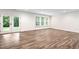 Spacious basement area illuminated by natural light from windows and a double-door walkout to the yard at 1030 Steinbeck Dr, Durham, NC 27703