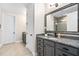 Bathroom featuring gray cabinets, granite countertops, and a decorative mirror at 1030 Steinbeck Dr, Durham, NC 27703