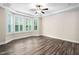 Comfortable bedroom features wood floors, tray ceiling with fan, and bay windows at 1030 Steinbeck Dr, Durham, NC 27703