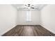 Large bedroom featuring wood-look floors, tray ceiling with fan, and a shuttered window at 1030 Steinbeck Dr, Durham, NC 27703