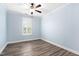 Light blue bedroom featuring hardwood floors and a window with shutters at 1030 Steinbeck Dr, Durham, NC 27703