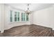 Bright dining room featuring beautiful hardwood floors, bay windows with shutters, and a decorative chandelier at 1030 Steinbeck Dr, Durham, NC 27703