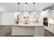 Spacious kitchen with white cabinetry, a granite island, and modern light fixtures at 1030 Steinbeck Dr, Durham, NC 27703