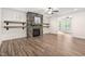 Cozy living room featuring a stone fireplace, floating shelves, and lots of natural light at 1030 Steinbeck Dr, Durham, NC 27703