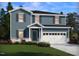 Charming two-story home with blue siding, white trim, an attached garage, and well-maintained landscaping at 1105 Landen Creek Ln, Zebulon, NC 27597