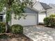 Attached garage featuring a concrete driveway and a white garage door, surrounded by lush landscaping at 1206 Chalk Maple Dr, Cary, NC 27519