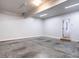 Spacious, unfinished garage featuring concrete floors, ample lighting and access door to the home at 1206 Chalk Maple Dr, Cary, NC 27519