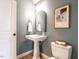 Stylish half bathroom with a pedestal sink, a modern mirror, and a toilet at 1206 Chalk Maple Dr, Cary, NC 27519