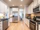 Spacious kitchen featuring stainless appliances, hardwood floors, and neutral cabinetry at 1206 Chalk Maple Dr, Cary, NC 27519