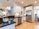 Open kitchen with stainless appliances, granite counters, and stylish white cabinets at 1206 Chalk Maple Dr, Cary, NC 27519
