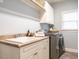Functional laundry room featuring a sink, cabinetry, and modern washer and dryer at 1206 Chalk Maple Dr, Cary, NC 27519