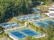 Aerial view of tennis courts with manicured landscaping, shaded seating areas, and ample space for recreational tennis games at 1206 Chalk Maple Dr, Cary, NC 27519