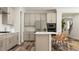 Bright kitchen featuring an island with seating, stainless steel appliances, and light wood flooring at 1224 Coral Cay Bnd, Wake Forest, NC 27587