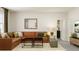 Bright living room featuring a brown L-shaped sofa, black coffee tables, and neutral rug at 1232 Coral Cay Bnd, Wake Forest, NC 27587