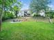 Large, well-maintained backyard with a fire pit, swing set, and mature trees at 12424 Beauvoir St, Raleigh, NC 27614