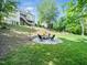 Landscaped backyard featuring a stone fire pit, swing set, and lush green lawn at 12424 Beauvoir St, Raleigh, NC 27614