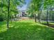 Expansive backyard with a trampoline, fire pit, stone walkway, and green lawn at 12424 Beauvoir St, Raleigh, NC 27614
