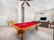 Finished basement with pool table, foosball table, comfortable seating, and large windows at 12424 Beauvoir St, Raleigh, NC 27614