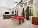 Finished basement with a pool table, comfortable seating, and large windows with curtains at 12424 Beauvoir St, Raleigh, NC 27614