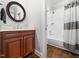 Bathroom with dark cabinets, mirror, and a shower with a shower curtain at 12424 Beauvoir St, Raleigh, NC 27614