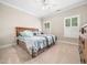 Bedroom with neutral carpet and paint, ceiling fan, wood bed frame and windows with shutters at 12424 Beauvoir St, Raleigh, NC 27614