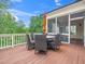 Outdoor deck with dining table, chairs and umbrella next to a screened in porch at 12424 Beauvoir St, Raleigh, NC 27614