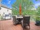 Exterior deck with dark wicker table and chairs, grill, and lush foliage at 12424 Beauvoir St, Raleigh, NC 27614
