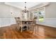 Dining room with hardwood floors, wainscoting, chandelier, and bright windows at 12424 Beauvoir St, Raleigh, NC 27614