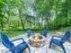 Cozy fire pit area with stone surround and blue Adirondack chairs at 12424 Beauvoir St, Raleigh, NC 27614