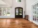 Bright foyer featuring hardwood floors, white walls, and a large window and double glass doors at 12424 Beauvoir St, Raleigh, NC 27614