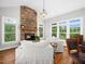 Cozy living room with stone fireplace and many windows offering outdoor views at 12424 Beauvoir St, Raleigh, NC 27614