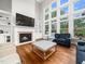 Comfortable living room with hardwood floors, fireplace, built-ins, and tall windows at 12424 Beauvoir St, Raleigh, NC 27614