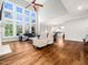 Bright living room with hardwood floors, high ceilings, large windows, and a ceiling fan at 12424 Beauvoir St, Raleigh, NC 27614