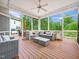 Screened-in porch featuring wicker furniture and a ceiling fan overlooking a wooded backyard at 12424 Beauvoir St, Raleigh, NC 27614
