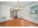 Bright dining room with hardwood floors, wainscoting, chandelier, and natural light at 1401 Brewer Jackson Ct, Wake Forest, NC 27587