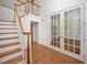 Bright foyer with hardwood floors, staircase, and French doors leading to another room at 1401 Brewer Jackson Ct, Wake Forest, NC 27587