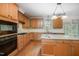 Spacious kitchen featuring wood cabinetry, granite countertops, stainless appliances, and island with seating at 1401 Brewer Jackson Ct, Wake Forest, NC 27587