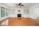 Bright living room featuring hardwood floors, fireplace, built-in shelving, and large windows at 1401 Brewer Jackson Ct, Wake Forest, NC 27587