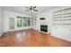 Spacious living room featuring hardwood floors, built-in shelves, fireplace, and natural light at 1401 Brewer Jackson Ct, Wake Forest, NC 27587