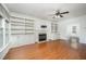 Cozy living room with a fireplace, built-in bookshelves, hardwood floors, and a ceiling fan at 1401 Brewer Jackson Ct, Wake Forest, NC 27587