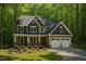 Beautiful two-story home with dormer windows, a two-car garage, and surrounded by lush greenery at 1412 Auman Rd, Raleigh, NC 27603