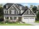 Charming two-story home featuring a two-car garage, dormer windows, and well-manicured landscaping at 1412 Auman Rd, Raleigh, NC 27603